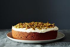 a cake sitting on top of a plate covered in frosting and pistachio