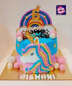 a birthday cake decorated with an image of a unicorn and rainbows on it's side