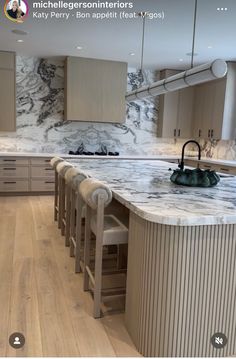 a kitchen with marble counter tops and wooden floors