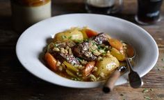 a white bowl filled with food on top of a wooden table