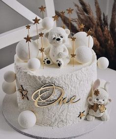 a white cake decorated with teddy bears and stars