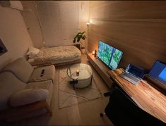 a living room with two laptops on the table and a bed in the corner