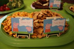 a green plate topped with lots of food next to plates of crackers and vegetables