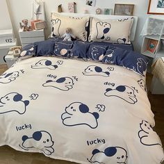 a bed covered in blue and white sheets with cartoon dogs on the comforter, along with matching pillow shampoos