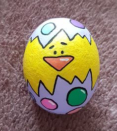 a painted easter egg sitting on top of a carpet