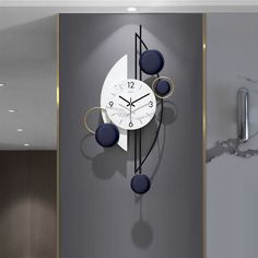 a modern clock on the wall in an office building with marble flooring and grey walls