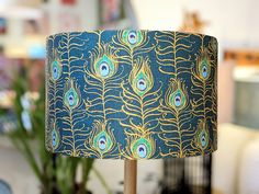 a peacock print lamp shade sitting on top of a table