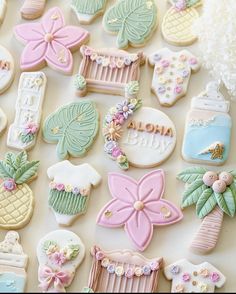 some decorated cookies are laying out on a white surface with pink, green and blue decorations