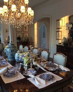 the dining room table is set with blue and white china