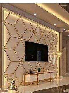 a living room with a large tv mounted to the wall and gold accents on the walls