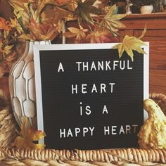 a sign that says a thank heart is a happy heart in front of some autumn leaves