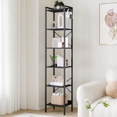 a living room with a white chair and book shelf