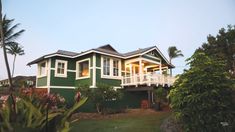 a green house with white trim and balconies