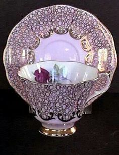 a purple and white bowl with a flower in it