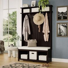 a room with a bench, coat rack and pictures on the wall above it that is filled with items