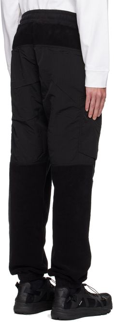 Garment-dyed cotton-blend fleece and crinkled Nylon-TC taffeta sweatpants. · Paneled construction · Drawstring at elasticized waistband · Two-pocket styling · Elasticized cuffs · Zip pocket at outseams · Detachable felted logo patch at zip pocket Supplier color: Black Supplier code: 811562753 Winter Utility Nylon Parachute Pants, Winter Nylon Parachute Pants With Pockets, Winter Nylon Pants With Pockets, Winter Nylon Bottoms With Side Pockets, Outdoor Nylon Pants With Patch Pockets, Relaxed Fit Nylon Sweatpants With Side Pockets, Black Cotton Utility Sweatpants, Outdoor Nylon Sweatpants With Side Pockets, Midweight Nylon Cargo Pants With Pockets