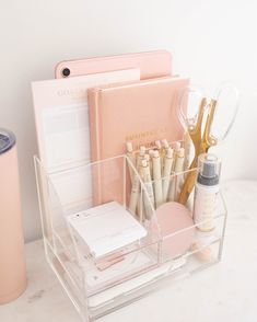 an organized desk with pens, notebooks and other office supplies on top of it