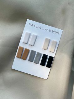 the olive leaf designs book is open to show different shades of greys and browns