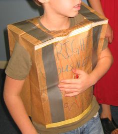 a young boy wearing a cardboard box costume