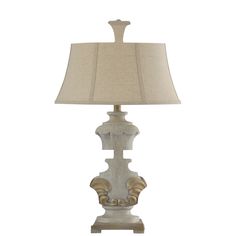 a white lamp with a beige shade on it