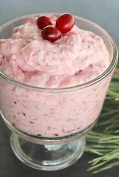 a bowl filled with cranberry fluff and topped with cherries