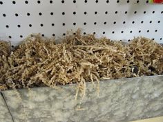 a pile of wood shavings sitting in a bin on top of a shelf