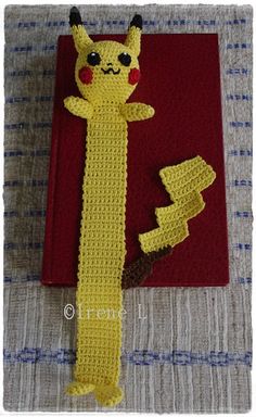 a crocheted bookmark with a pikachu character on it and a red book