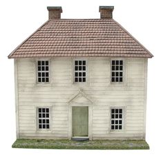 a white model house with a green door and windows