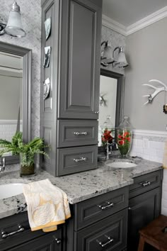 a bathroom with gray cabinets and marble counter tops