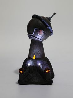 a small black object with lights on it's head and eyes in the shape of a spaceship