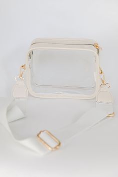 If you're a girl who is always on the go, then the Energetic Aesthetic Clear Crossbody Bag is crucial for stylish success! This chic handbag is designed with a faux leather trim and a clear body. It features a functional zipper closure and a knit removable adjustable crossbody strap. Use the Energetic Aesthetic Clear Crossbody Bag for game days! Available in 2 colors. Faux Leather Trim Clear Body Gold Hardware Removable Adjustable Crossbody Strap Functional Zipper Closure One Size | Length 5" | Energetic Aesthetic, Chic Handbags, Store Hours, Bag Dress, Ivory Color, Crossbody Strap, Leather Trim, Leather Trims, Gold Hardware