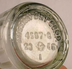 a close up of a person holding a glass jar with numbers on the bottom and inside