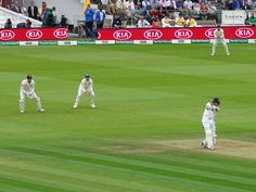 the men are playing a game of cricket on the field