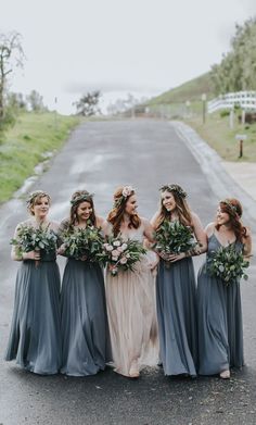 the bridesmaids are all dressed in gray dresses and flower crowns, with greenery on their heads