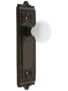 an ornate door handle with a white ball on it