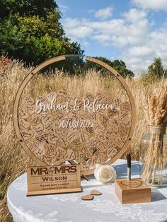 a wooden sign sitting on top of a table next to a vase filled with flowers