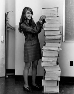 a woman standing in front of a stack of books with the caption'this is computer scientist margartt hamiton with the results of the self - testing code her team wrote for