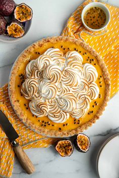 a pie sitting on top of a table next to other desserts and utensils