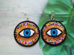 These round evil eye post earrings would make a perfect and unique gift for family, friend, or yourself. If you like these bead embroidery earrings, but would like them in a different color please email me because I do special orders. ★READY TO SHIP Made with love and care about you!♥ ★DIMENSIONS: 7.5*5.5 cm (2.95*1.96 Inches) ★The colors can slightly differ from the photo because of photography lighting and monitor settings. ★ESTIMATED SHIPPING TIMES: North America: 2-4 weeks Europe: 1-3 weeks Multicolor Round Evil Eye Jewelry, Bohemian Evil Eye Earrings As Gift, Handmade Circular Beaded Earrings For Gifts, Earrings Embroidery, Round Evil Eye, Embroidery Earrings, Eye Gift, Evil Eye Earrings, Large Eyes