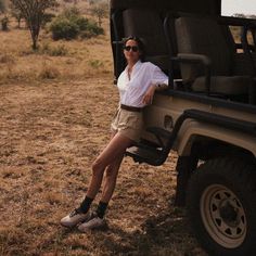 a woman sitting on the back of a safari vehicle