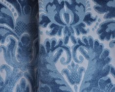 the blue and white fabric has an intricate design on it's side, as well as