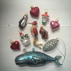 a collection of christmas ornaments including a humpback whale and other sea creatures are arranged on a white surface