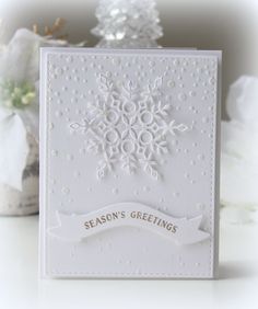 a white card with snowflakes on it and the words season's greetings