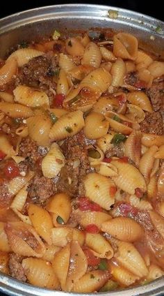 a pot filled with pasta and meat on top of a stove