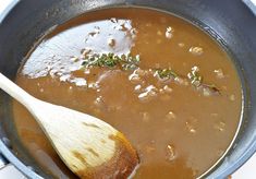 a wooden spoon in a pot filled with soup