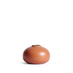 a brown vase sitting on top of a white surface