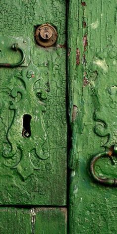 an old green door with metal handles and knobs