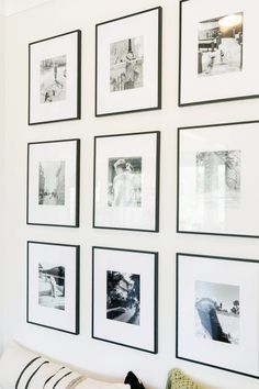 black and white photographs hang on the wall above a couch