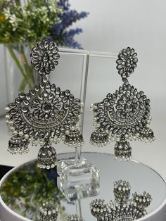 We bring beautiful Jewelry sure to elevate any look! Kindly pay attention to all photos and video and ask questions about the item prior to ordering. Elegant Festive Jhumkas With Mirror Work, Bollywood Style Silver Bridal Earrings With Tilla, Silver Tilla Bollywood Bridal Earrings, Silver Tilla Jhumkas For Party, Silver Danglers With Stone Work For Eid, Silver Stone Work Danglers For Eid, Silver Bollywood Bridal Earrings With Latkans, Festive Silver Chandelier Earrings With Stone Work, Silver Chandbalis With Stone Work For Eid