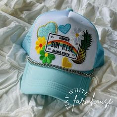 This Hawaii sunrise hat is adorable with such a tropical theme! All patches are attached via commercial heat press! Check out my other listings for other options, if you don't see what you are looking for just message me! I love doing custom orders as well to make your dreams a reality! This listing is for the hat only! The hat is a one-size-fits-all snapback style trucker hat that can be adjusted! Please remember that each of my hats is made-to-order, so the size of patches & placement may slightly differ than the hat pictured! The chain is available in silver tone or gold tone! If you have a preference please put it in the notes at checkout! Otherwise I will default to what is shown in the first example photo! The chain is 8.5mm curb chain and is attached to the hat using lobster claw cl Casual Summer Trucker Hat With Embroidered Patch, Beach Trucker Hat, Trendy Summer Trucker Hat With Embroidered Patch, Summer Trucker Hat With Patches, Trucker Hat With Patches, Fun Trucker Hat With Embroidered Patch, Trucker Hat Patch